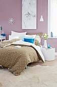 Bettwäsche im Punktedessin auf Doppelbett in romantisch gestaltetem Schlafzimmer, pastell lila Farbton an Wand