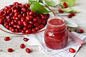 Fresh cornelian cherries and a jar of jam