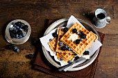 A stack of waffles with blueberries and blackberries