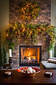 Weihnachtlich geschmückter Kamin mit brennendem Kaminfeuer in gemütlichem Wohnzimmer