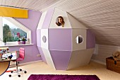 Selbstgebaute Raumkapsel aus weissen und violetten Holzpaneelen, unter Dachschräge im Kinderzimmer, Mädchen hinter Guckloch