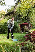 Man raking leaves in garden
