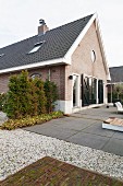 Renovated, brick house with large, grey stone-flagged terrace