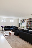 Spacious interior with black sofa combination, child's chair with matching table and ecru rug