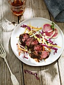 Beef steak and coleslaw on a wooden table