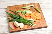 Sliced vegetables and apples on a chopping board