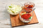 Geschnittenes Gemüse mit Chilipaste und gesalzener Chinakohl auf Schneidebrett (Zutaten für Kimchi)