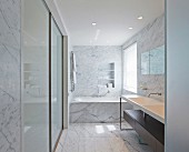 Private Apartment, London, United Kingdom. Architect: Hill Mitchell Berry, 2014. Elegant marble bathroom with minimalist washstand and bathtub below window