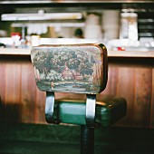 Bar stool with picture of angler in landscape on backrest