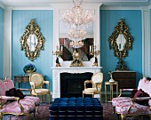 Rococo salon with Louis XVI sofas and armchairs and two mirrored sconces on blue wall