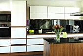 Elegant walnut kitchen with white front panels and black granite worksurface; island counter in foreground