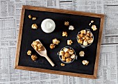 Small buckets of caramel popcorn and milk on a blackboard