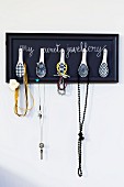 Hand-crafted jewellery rack with Chinese spoons as hooks mounted on wall