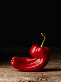 A red pepper on a rustic wooden table