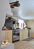 Rustikale, cremefarbene Küchenzeile mit Edelstahl Gasherd und weiße Holzverkleidung an Decke