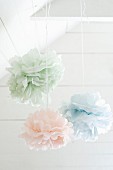 Pastel fabric flowers hung from white-painted wooden ceiling