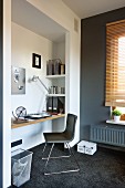 Designer chair at floating desk in niche with grey-painted wall to one side