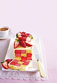 Checkerboard cake with strawberries and buttercream on serving platter