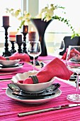 Place settings with hot pink linen napkins and place mats on festive table