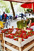 Strawberries and asparagus at a market stall
