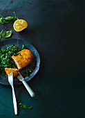 Turkey escalope with a coconut crust on a bed of spinach