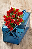 Bouquet of red roses in blue toolbox