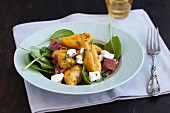 Pumpkin gnocchi with goat's cheese, Parma ham and baby spinach