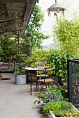 Terrasse eines Lofts mit Pflanzen und Bäumen, dazwischen kleiner Sitzplatz