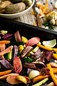 Vegetables with olive oil, rosemary, savory and fleur de sel on a baking tray