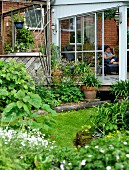View from flowering garden to extension with glass sliding door