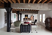 Loft-apartment lounge with black leather armchair, side table and round vintage cabinet against wall