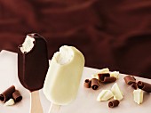 Milk chocolate-covered and white chocolate-covered ice cream sticks