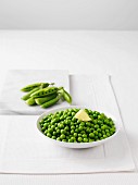 Fresh peas and a bowl of boiled peas with butter