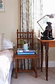 Antique, carved chair next to dog ornament on table