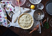 An unbaked blueberry pie, ingredients and baking utensils