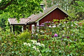 Wooden weekend cottage in lush garden