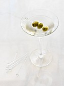 Ein Glas trockener Martini mit einem Oliven-Spiesschen