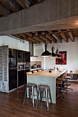 Dining counter with bar stools and two classic metal bar stools at one end in loft apartment with rustic wood-beamed ceiling