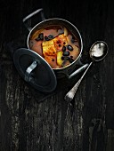Fischsuppe mit schwarzen Oliven in Kochtopf