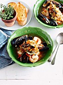 Brodetto (Italian seafood fish soup) in bowls; served with baguette