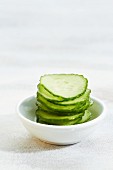 A stack of cucumber slice on a bowl