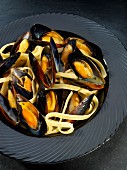 Mussels steamed in white wine on a bed of linguine