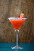 A strawberry daiquiri in a glass with a sugared rim
