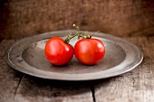 Two tomatoes on a metal plate