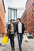 A couple with shopping bags holding hands in Brooklyn, New York City