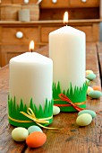 Easter decorations - pillar candles decorated with strips of felt on rustic wooden table
