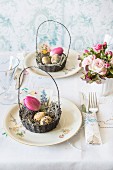 An Easter table decorated with bouquets and an Easter basket filled with eggs and a tulip