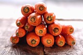 A stack of carrots on a wooden table