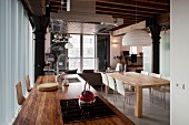 Kücheninsel mit rustikaler Holz-Arbeitsplatte und moderner Essplatz in einer Loft-Wohnung