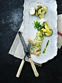 Baked fish with herb cream, potatoes and courgette